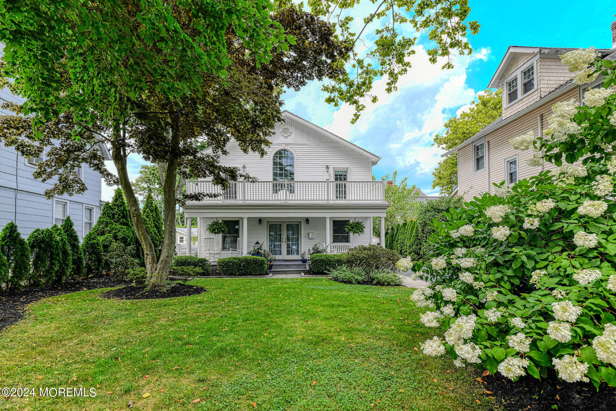 a front view of a house with a garden and plants