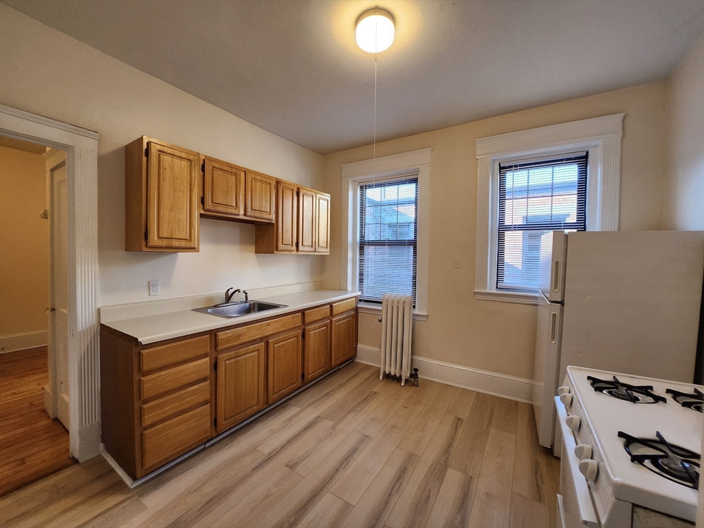 a kitchen with stainless steel appliances a sink cabinets and wooden floor