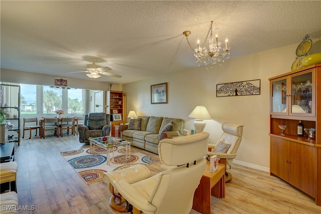 a living room with furniture dining table and a chandelier