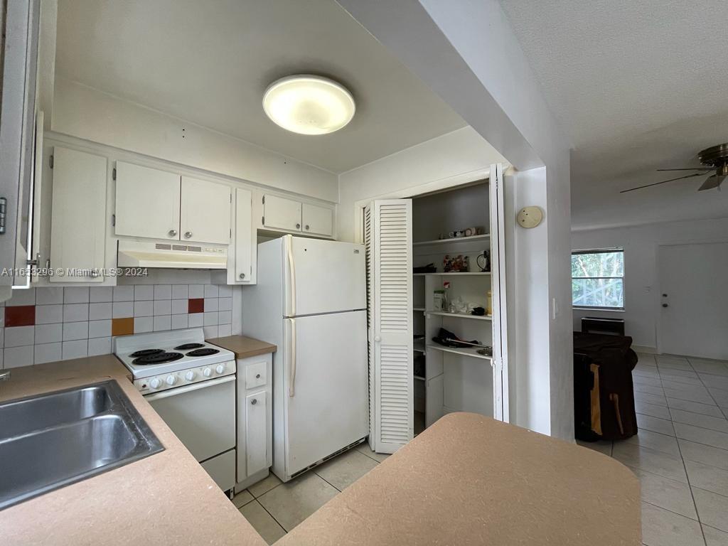 a kitchen with refrigerator and cabinets