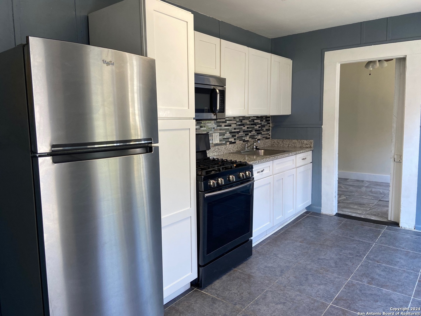 a white refrigerator freezer and a stove sitting inside of a kitchen