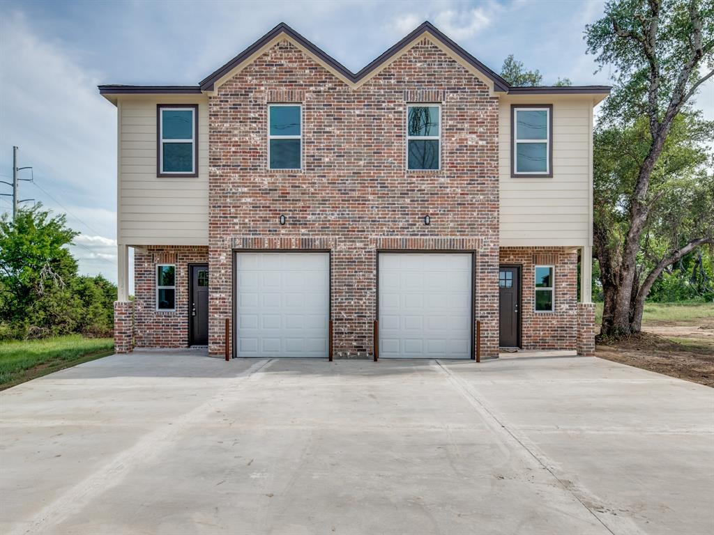 a front view of a house with yard and parking