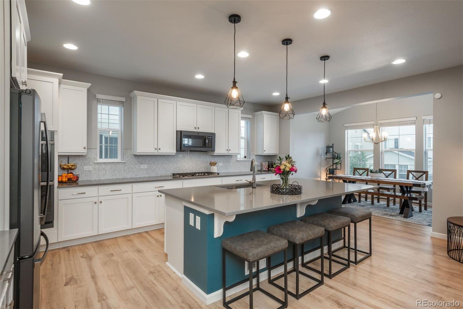 a kitchen with cabinets a sink appliances and wooden floor