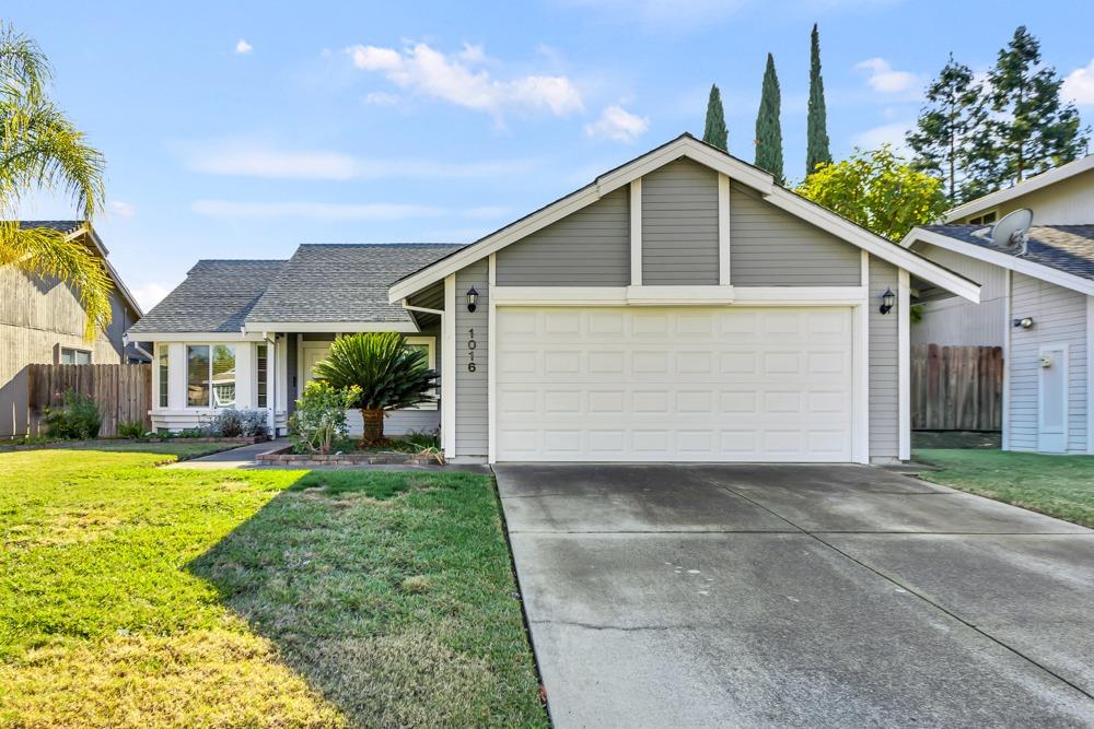 a front view of a house with a yard and garage