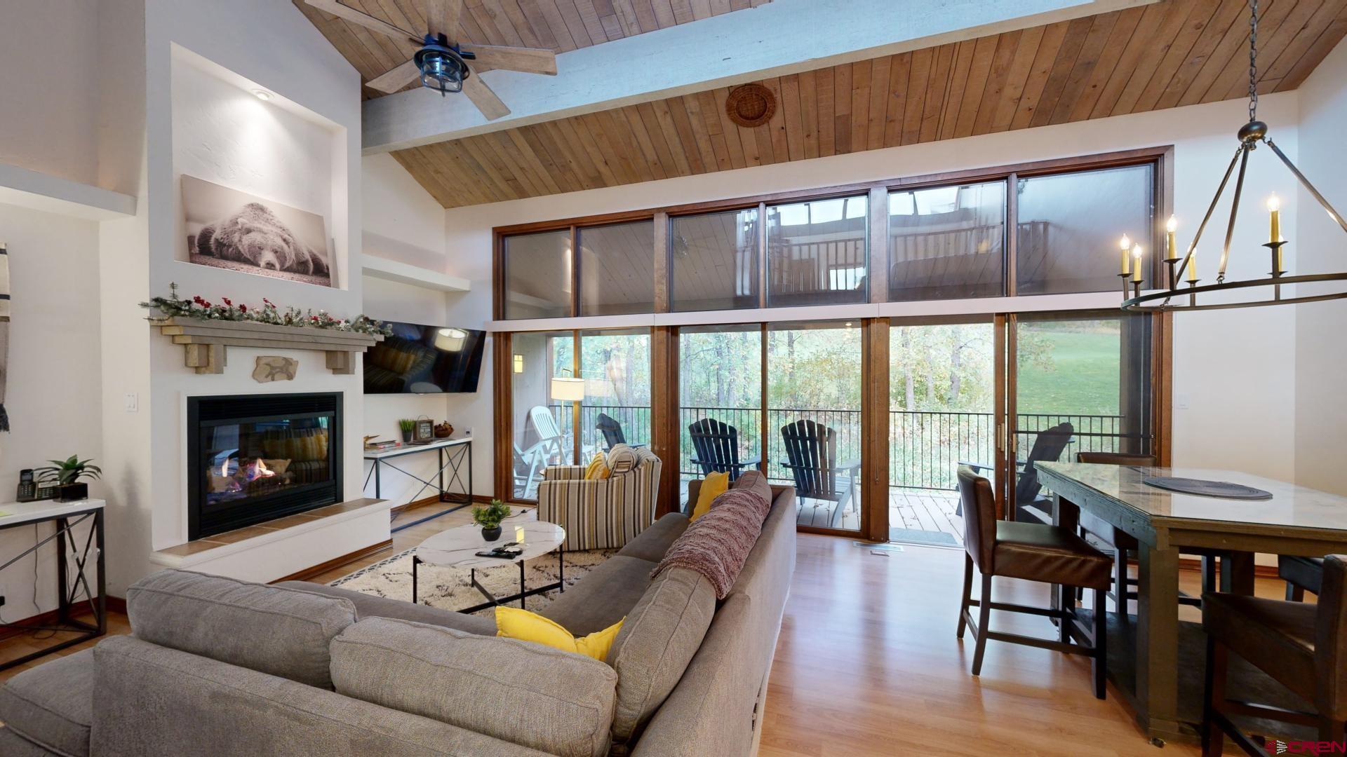 a living room with furniture a fireplace and a floor to ceiling window