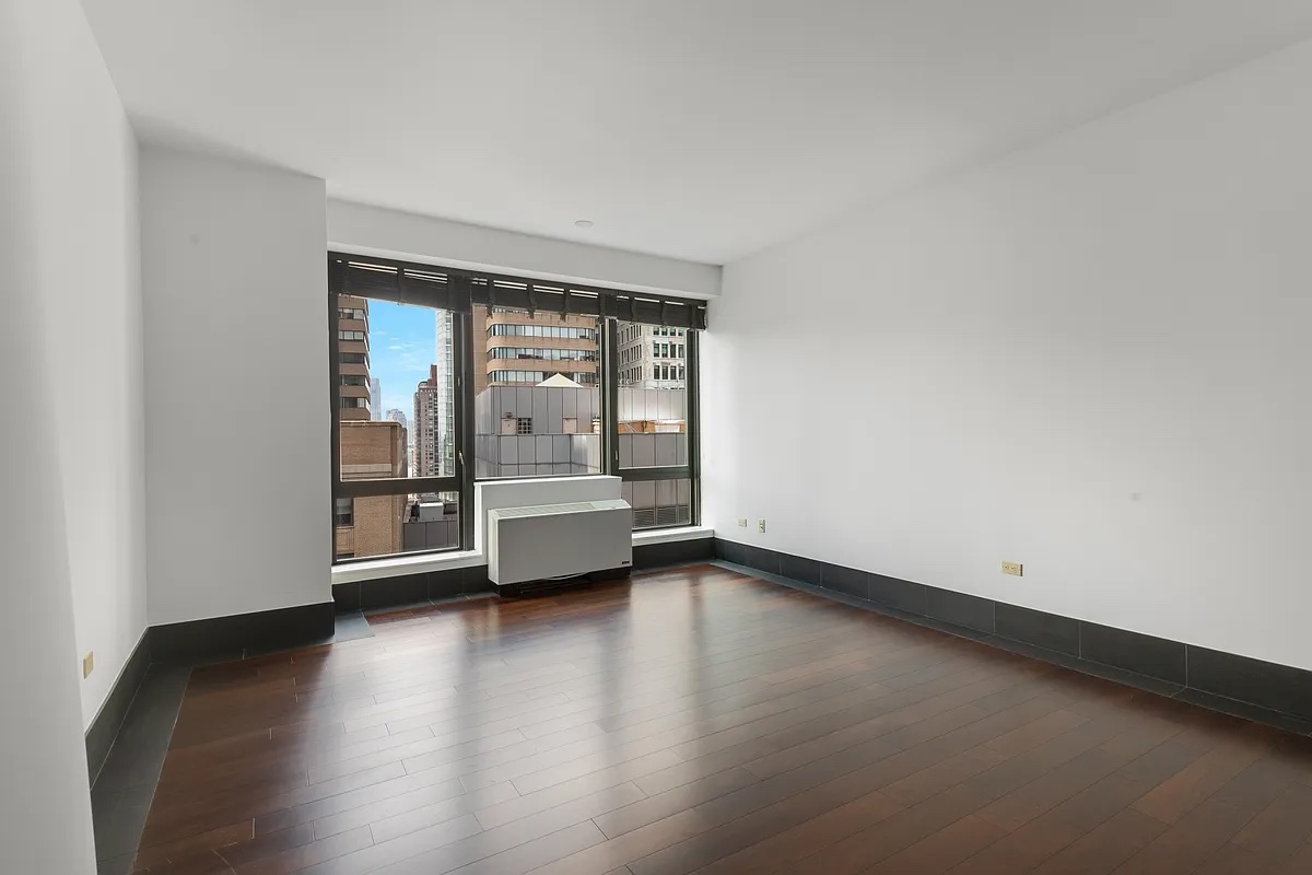 a view of a room with wooden floor and a window