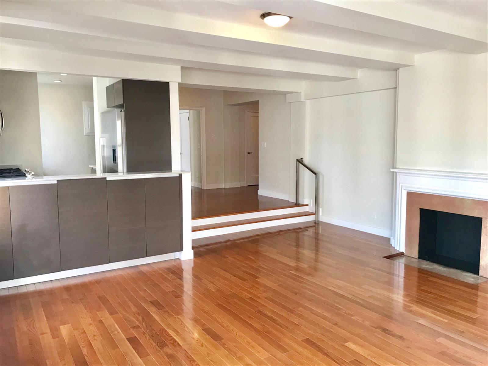 an empty room with wooden floor and fireplace