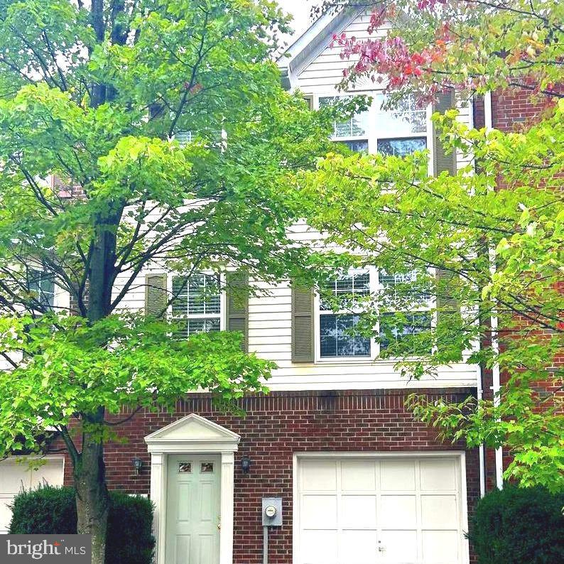 a front view of a house with a yard and potted plants