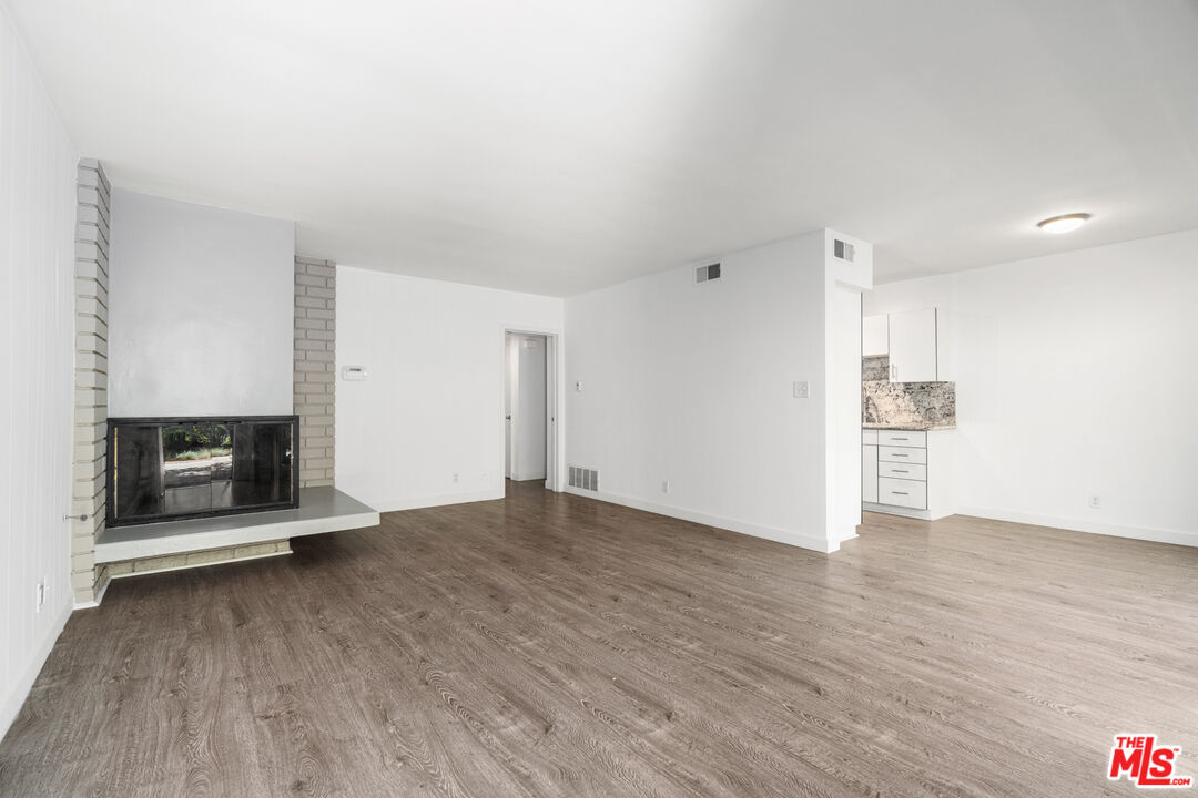 a view of a room with wooden floor and a fireplace