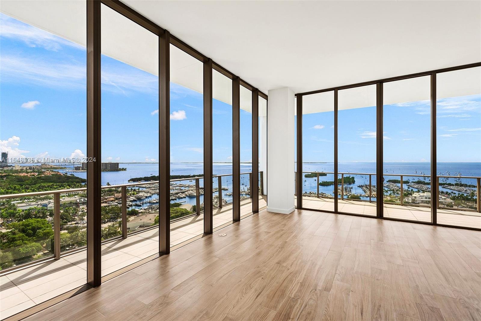 a view of an empty room with wooden floor and city view