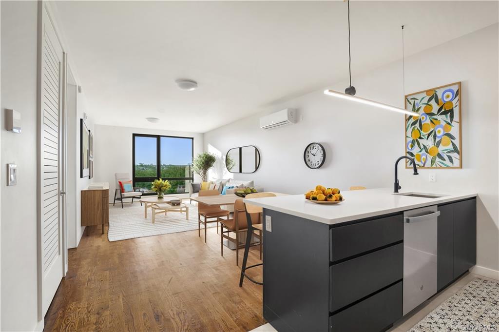 a living room with stainless steel appliances kitchen island a table and chairs in it