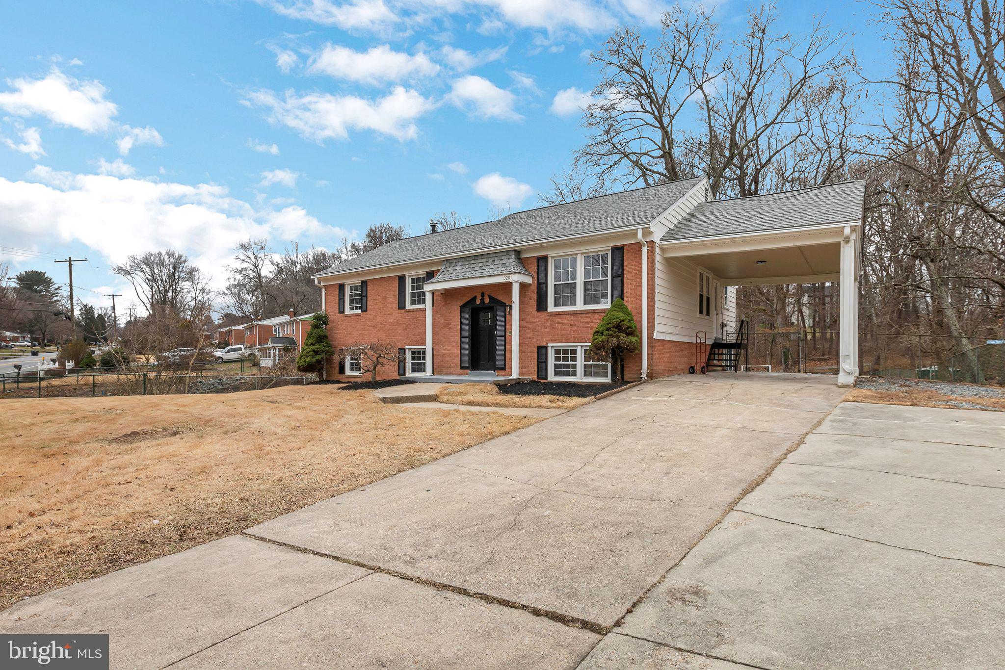 a front view of house with yard and trees around