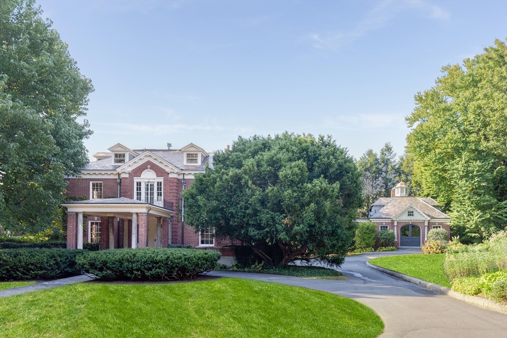 a view of a big house with a big yard and large trees