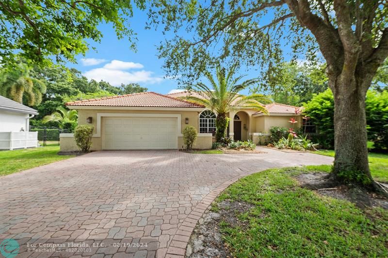 a front view of a house with a yard and a garage