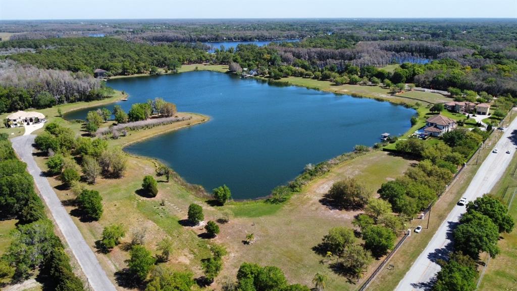 an aerial view of lake residential house with swimming pool and green space