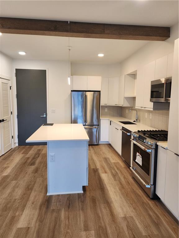 a kitchen with stainless steel appliances granite countertop a stove a sink and a refrigerator