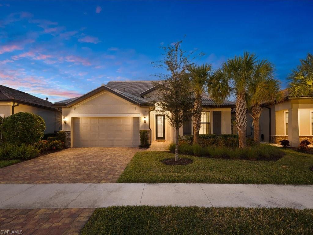 a front view of a house with a yard and trees