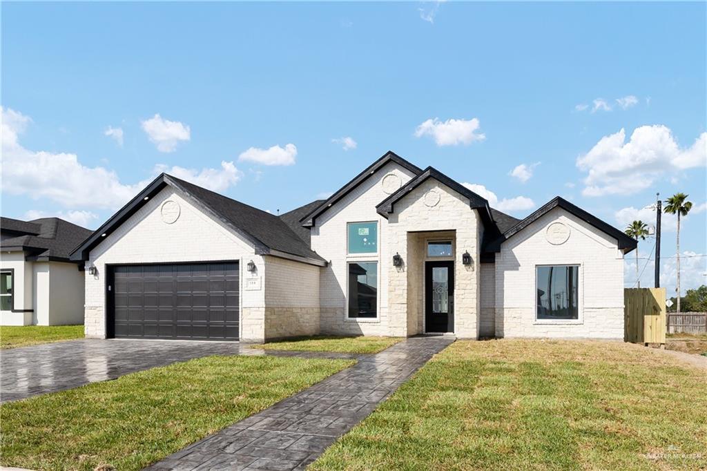 View of front of house featuring a garage and a front yard