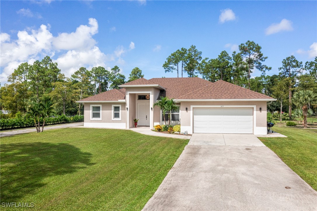 a front view of a house with a yard and trees