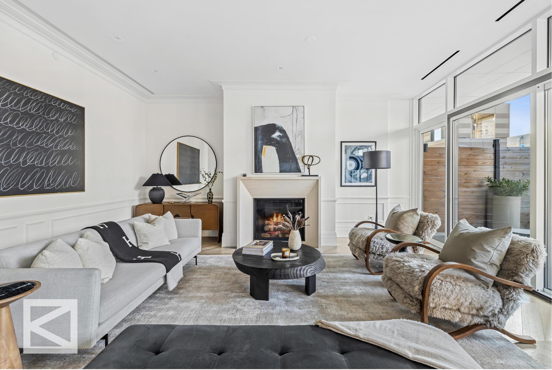 a living room with furniture two large windows and a fireplace