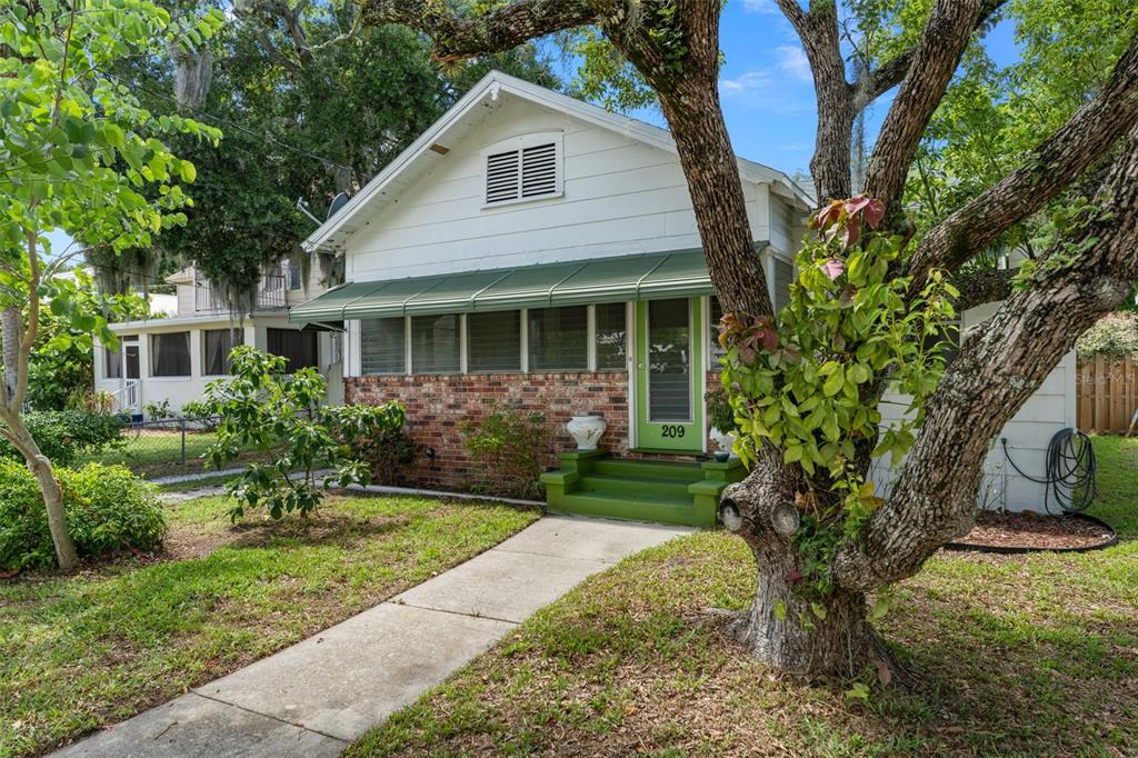 a view of a house with a yard and potted plants