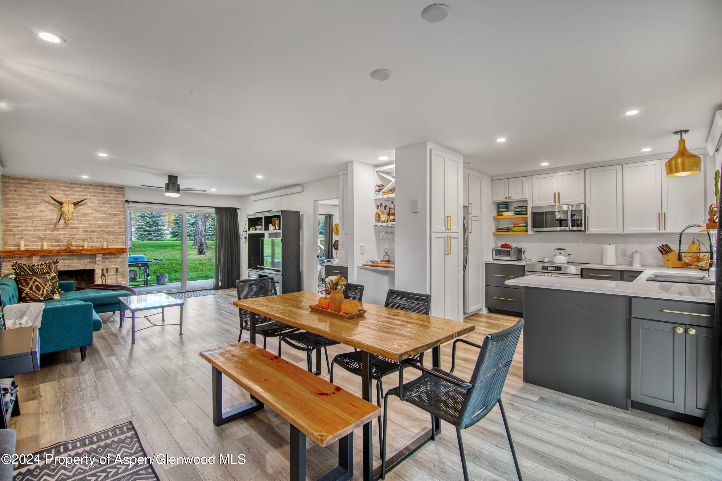 a kitchen with a dining table chairs and refrigerator