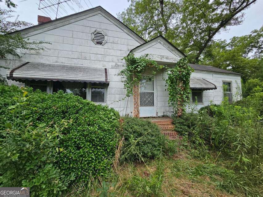 a front view of a house with a yard and trees