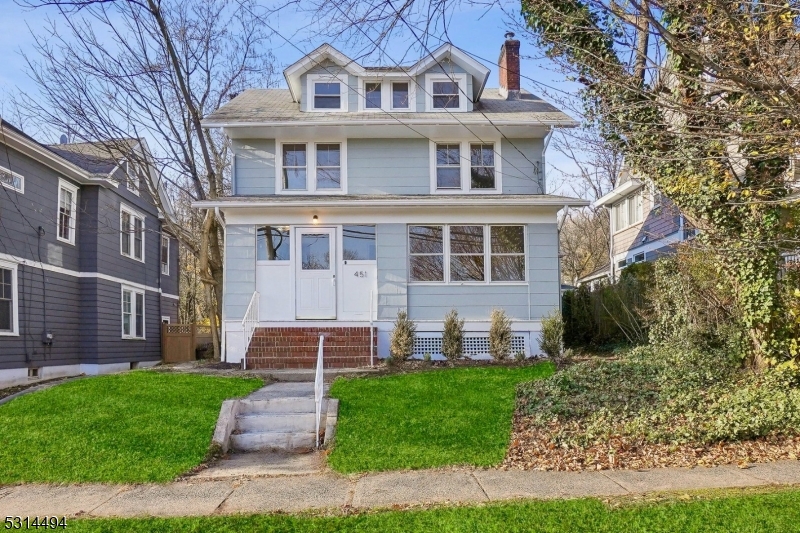 front view of a brick house with a yard