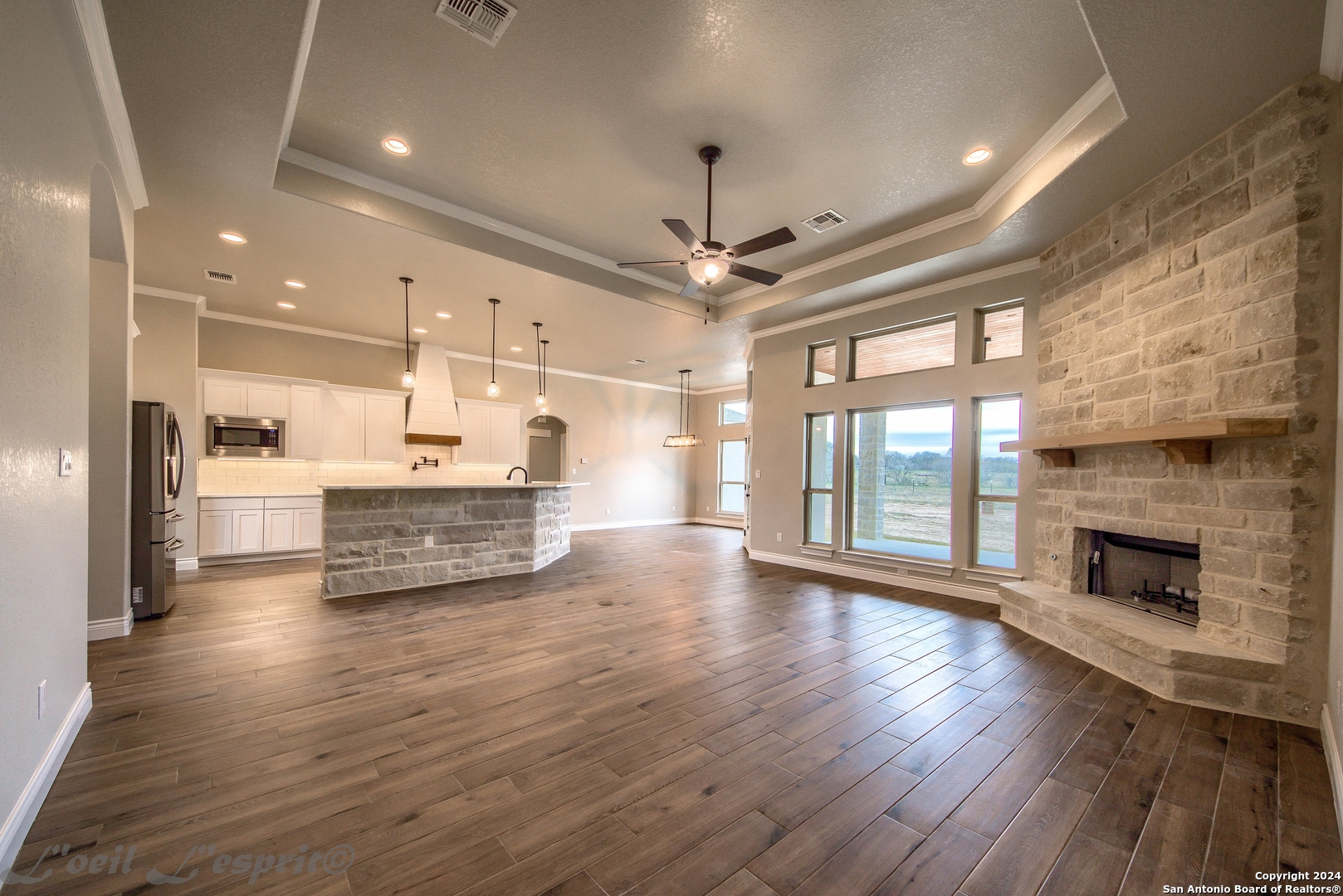 a view of an empty room with a fireplace and wooden floor