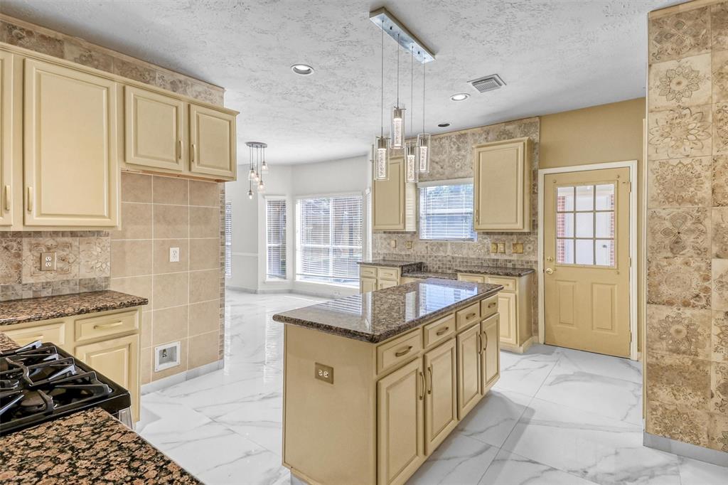 a large kitchen with stainless steel appliances granite countertop a sink and cabinets