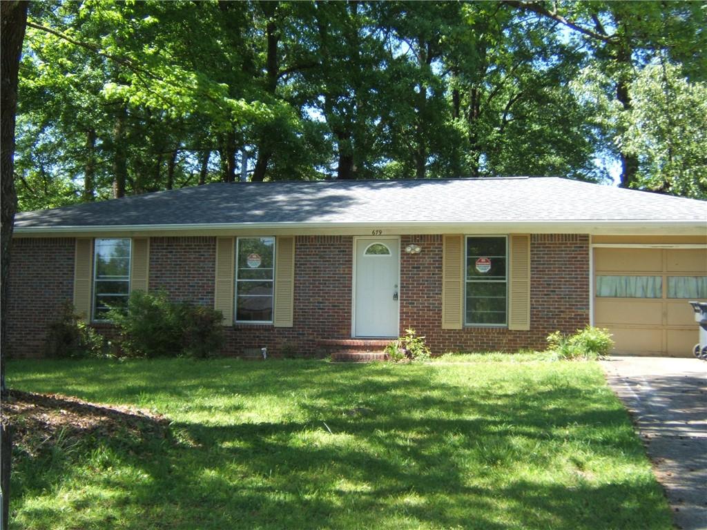 a front view of a house with a garden and yard