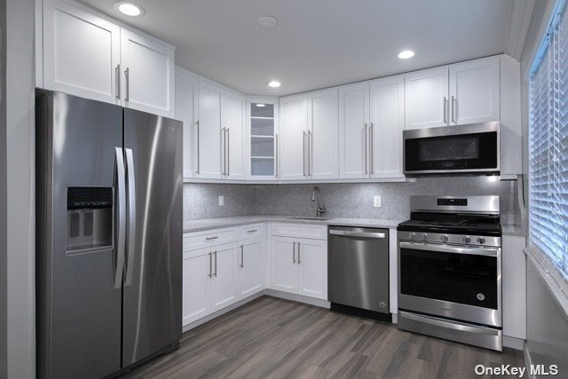 a kitchen with stainless steel appliances granite countertop a stove a refrigerator and a microwave