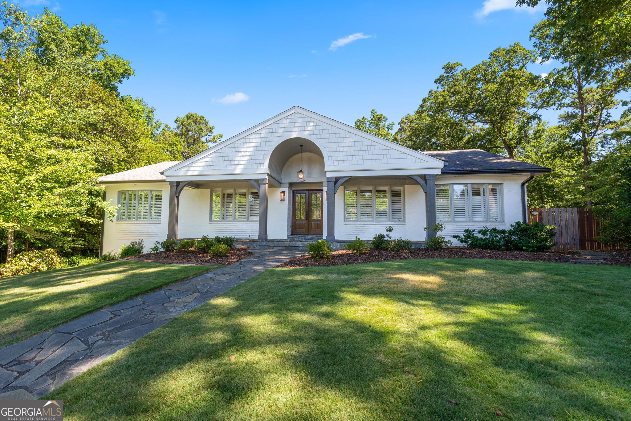 a front view of a house with a garden