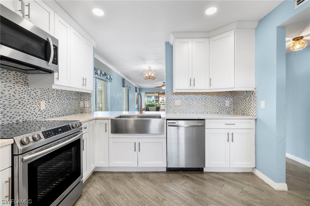 a kitchen with granite countertop a stove top oven microwave and cabinets