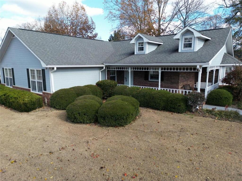 a view of a house with a yard and large tree