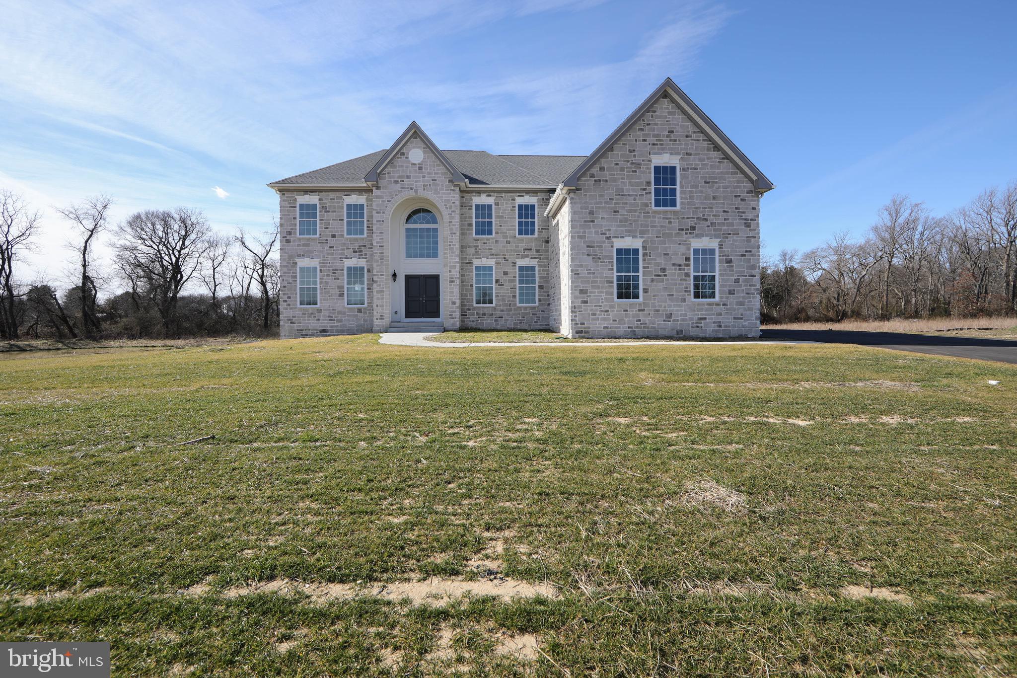 a large house with a big yard and large trees