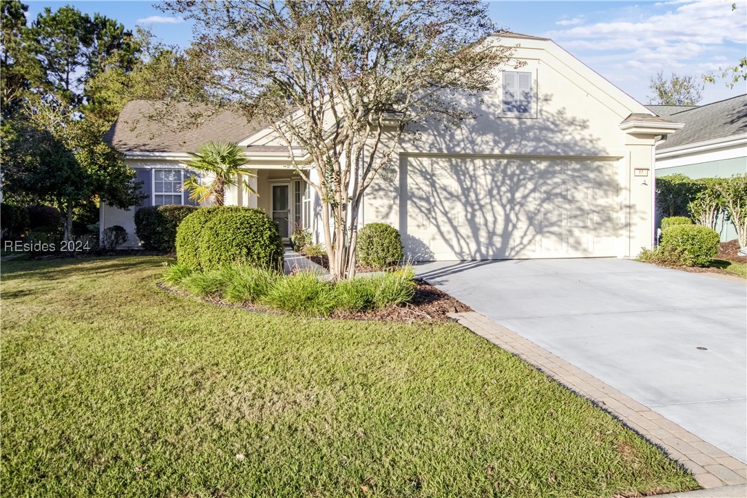 View of front of home with a garage and a front ya