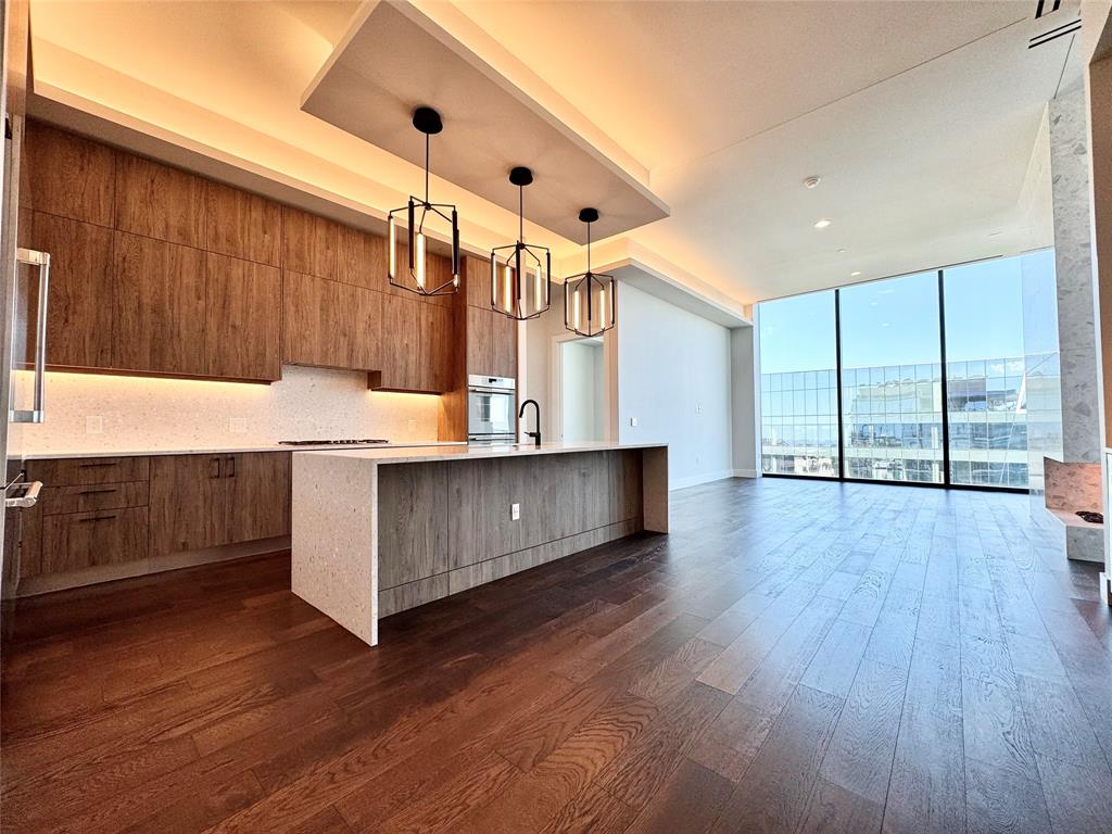 a kitchen with stainless steel appliances kitchen island wooden floors and wooden cabinets