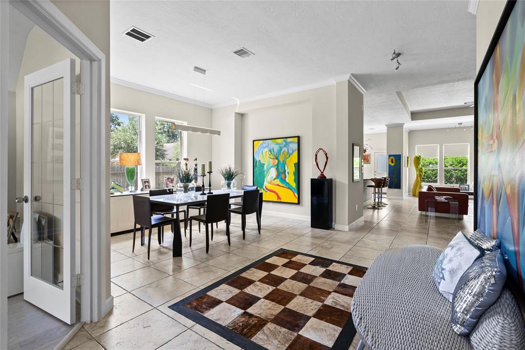 a living room with furniture a rug and a dining table