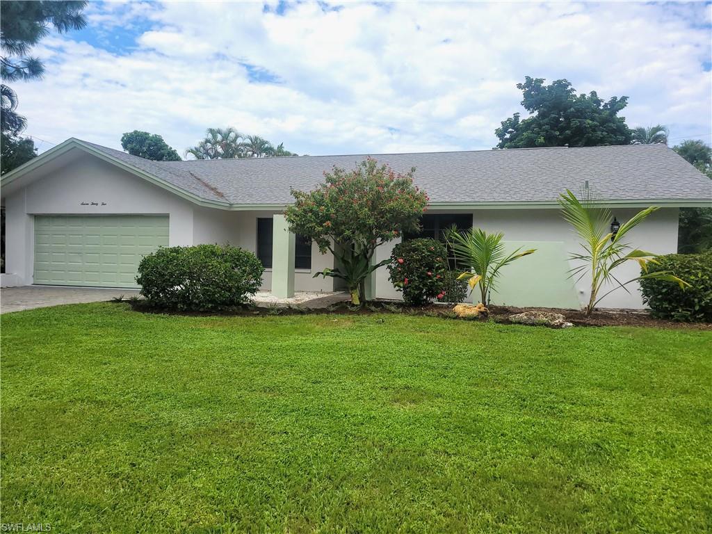 Single story home featuring a front yard and a garage