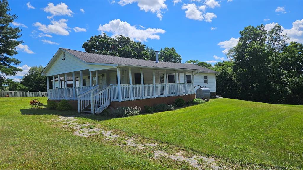 View of front of property featuring a front yard and a porch