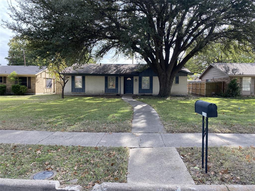 a front view of a house with a garden and trees