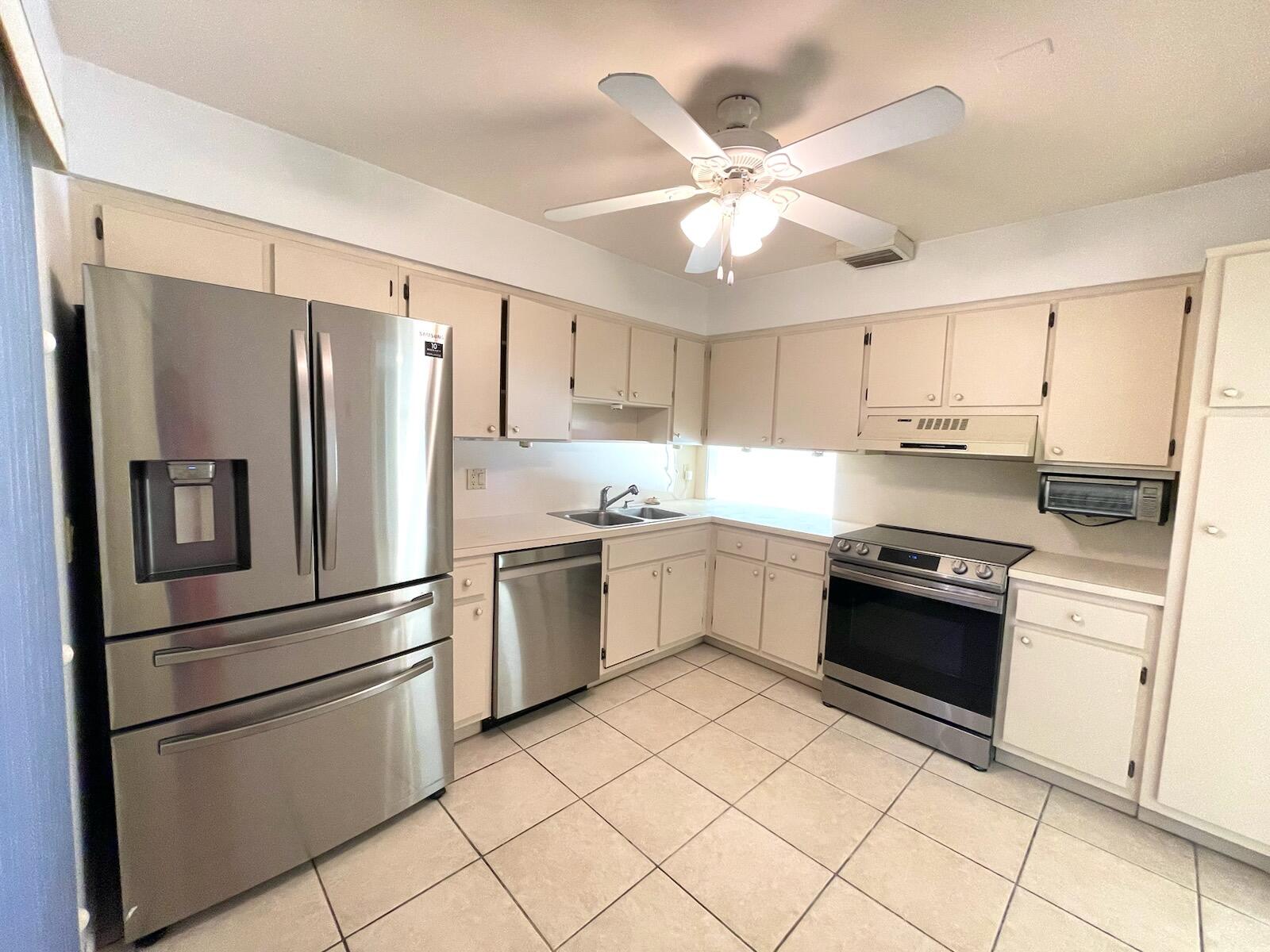 a kitchen with granite countertop stainless steel appliances and white cabinets