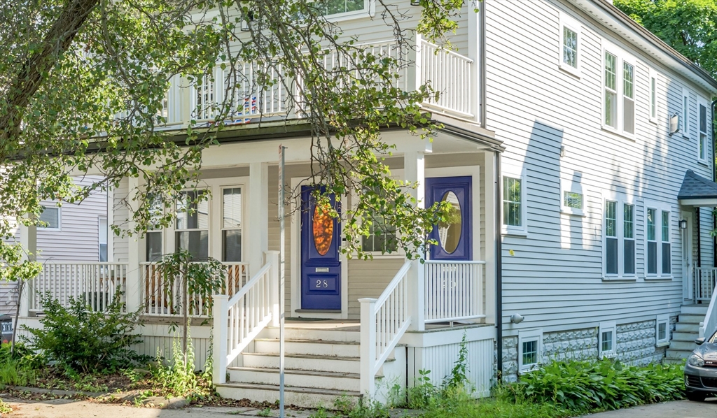 a front view of a house with a tree