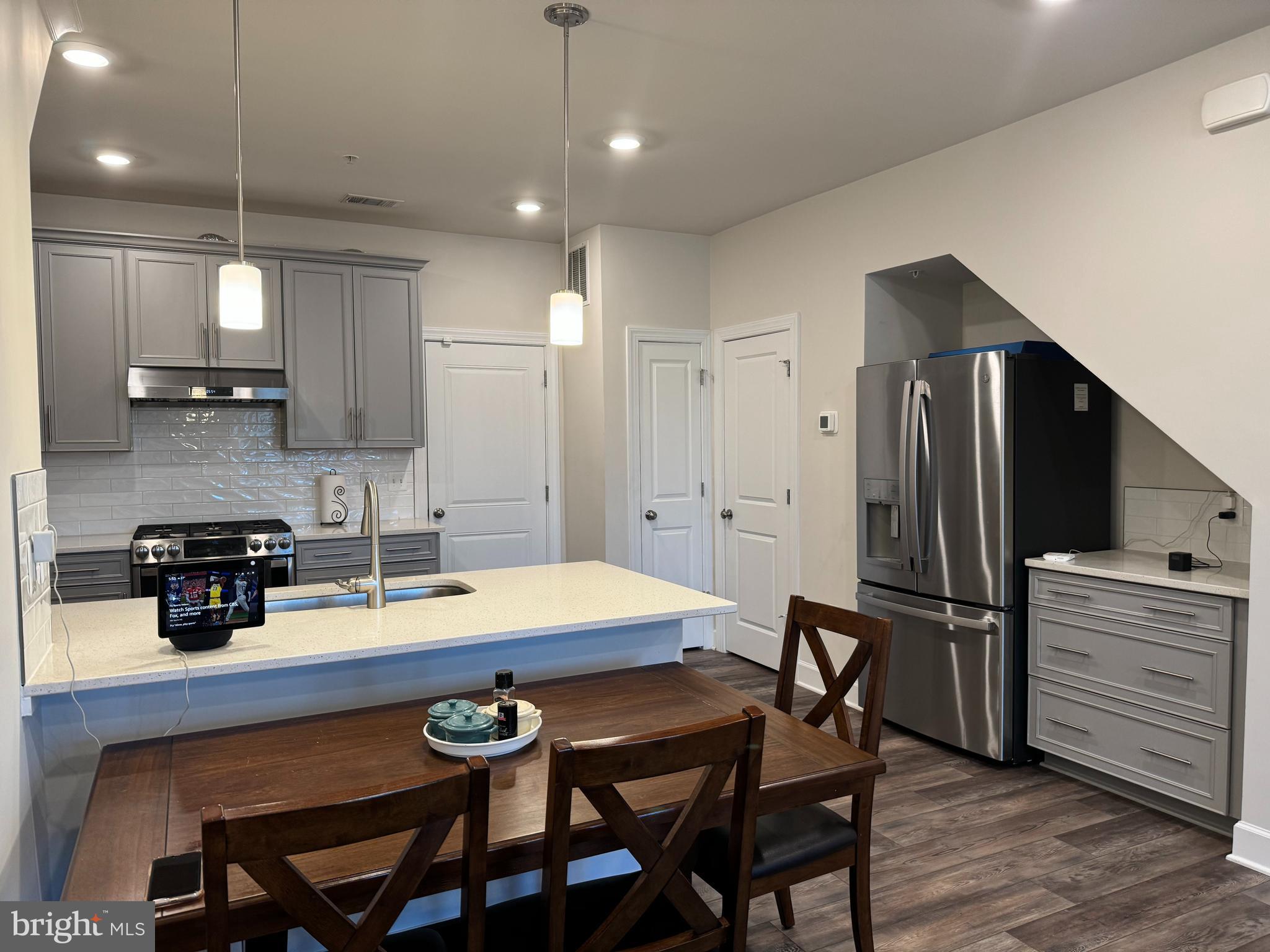 a kitchen with a table chairs refrigerator and microwave