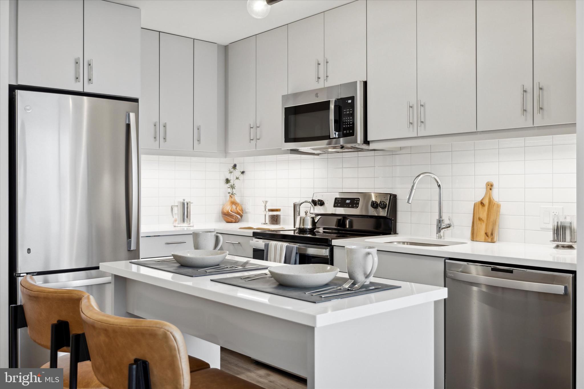 a kitchen with stainless steel appliances granite countertop a sink a stove and a refrigerator