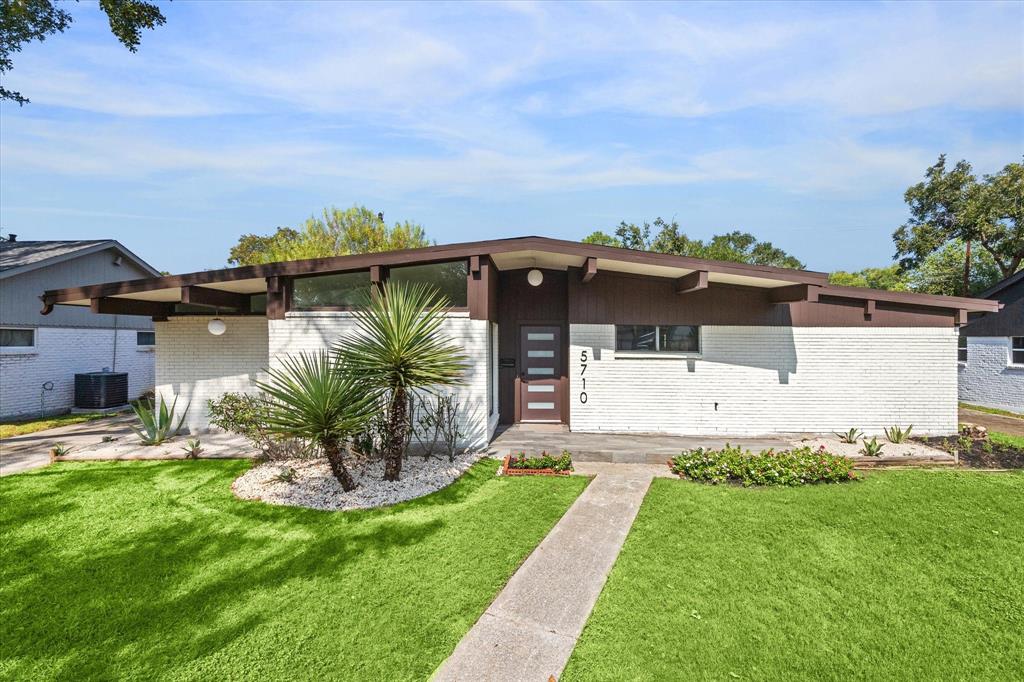 a front view of a house with a garden and yard