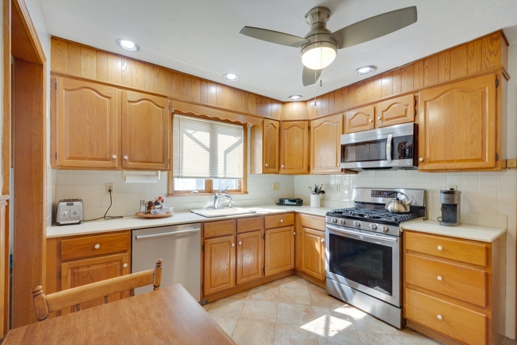 a kitchen with a sink stainless steel appliances cabinets and a window