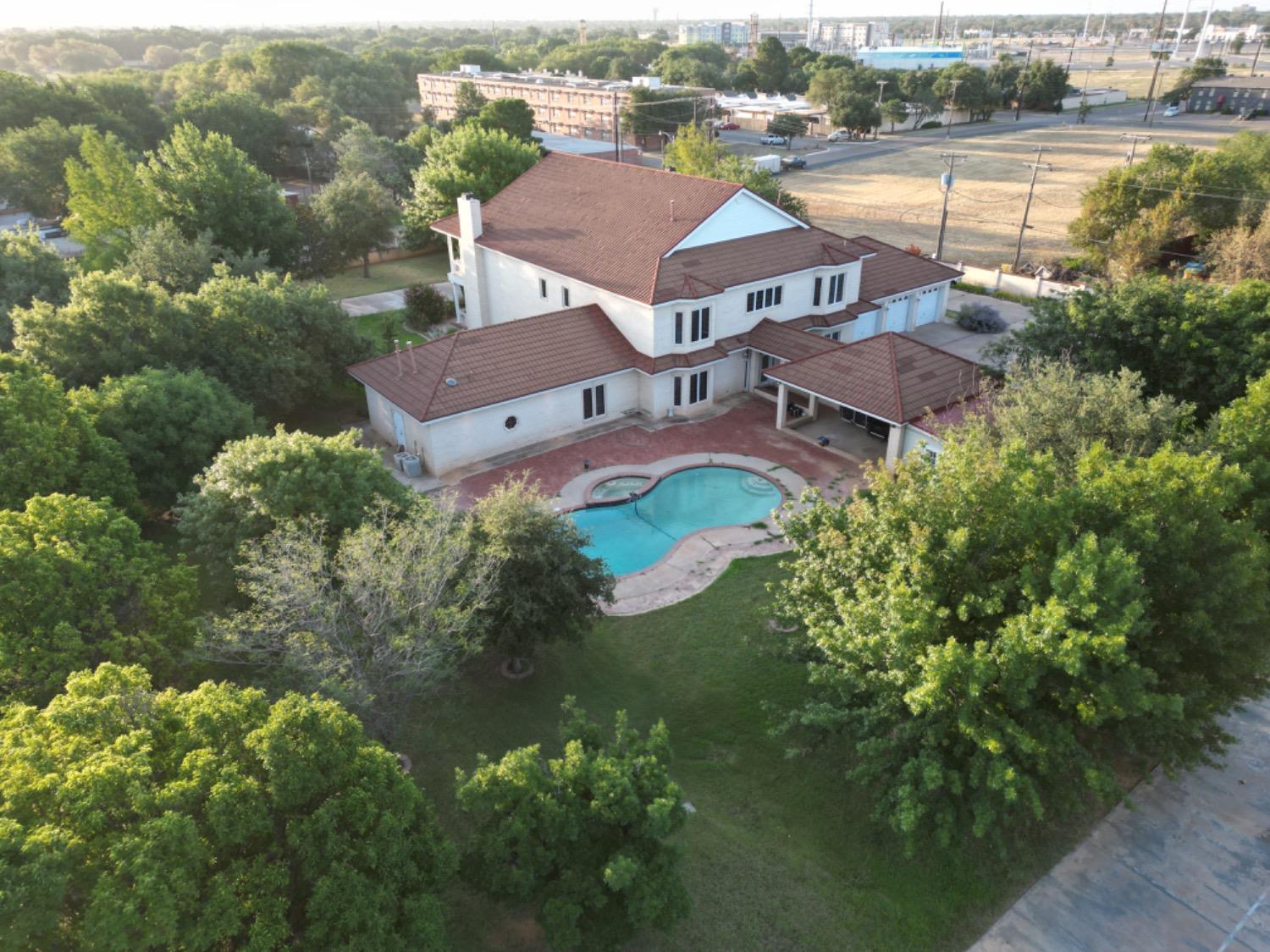 an aerial view of residential houses with outdoor space and trees