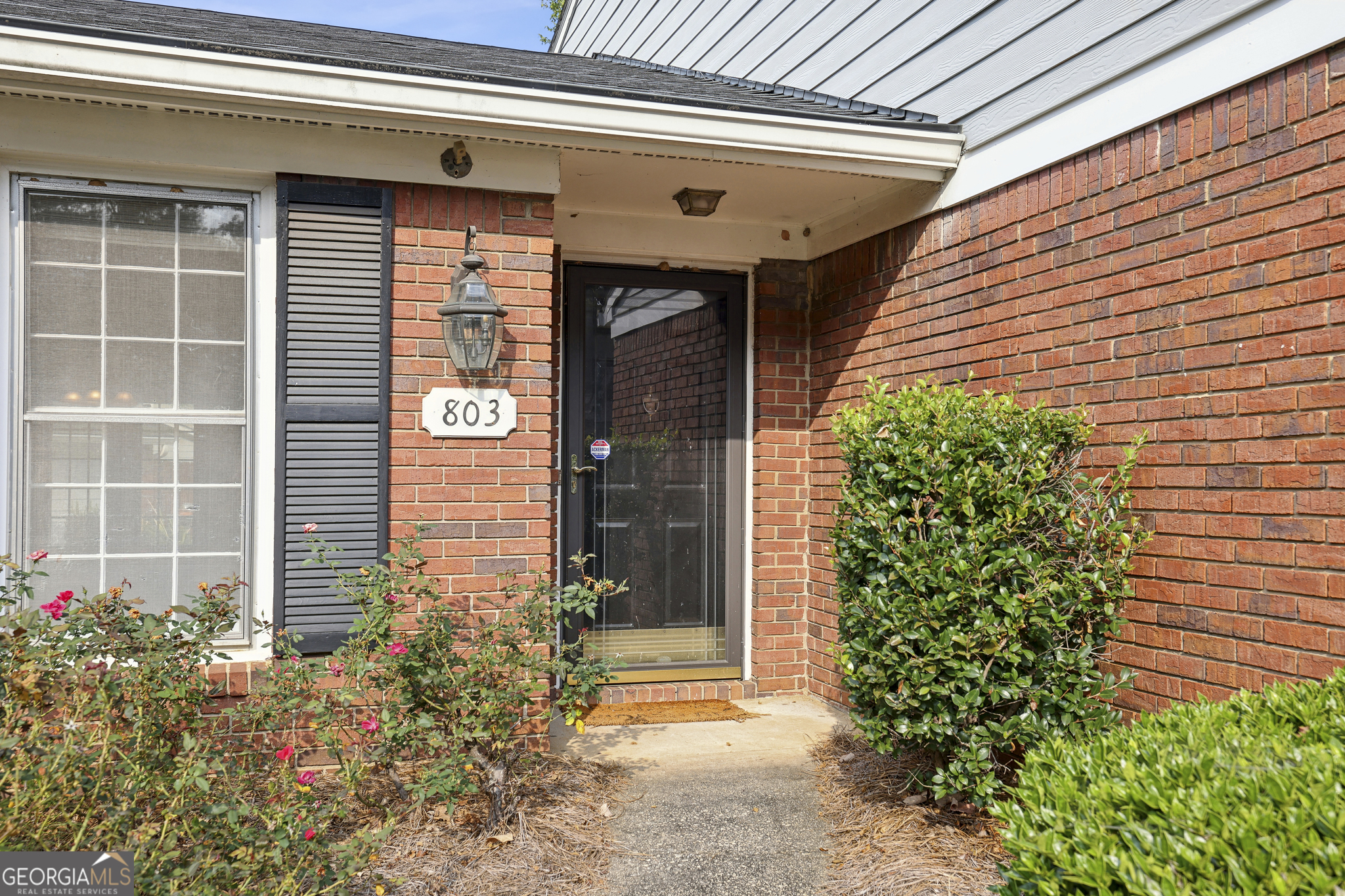 a front view of a house with plants